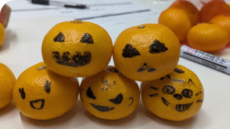 顔が描かれたみかんが積まれたハロウィンの飾り