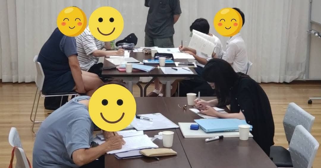 机を囲んで、それぞれのペースで学習に取り組む参加者とボランティア